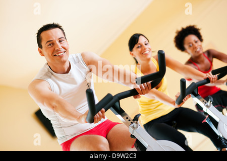 Tre persone la filatura in palestra, esercita per le loro gambe e cardio-training, solo gli arti e le ruote per essere visto Foto Stock