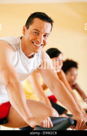 Tre persone la filatura in palestra, esercita per le loro gambe e cardio-training, solo gli arti e le ruote per essere visto Foto Stock