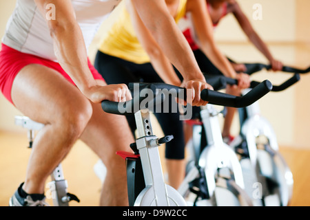 Tre persone la filatura in palestra, esercita per le loro gambe e cardio-training, solo gli arti e le ruote per essere visto Foto Stock