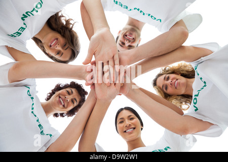 Allegro gruppo di volontari mettendo le mani insieme Foto Stock