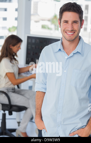 Bello photo editor in piedi con le mani in tasca Foto Stock