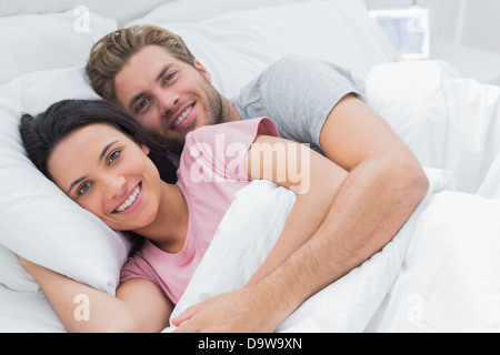 Giovane abbracciando a letto Foto Stock