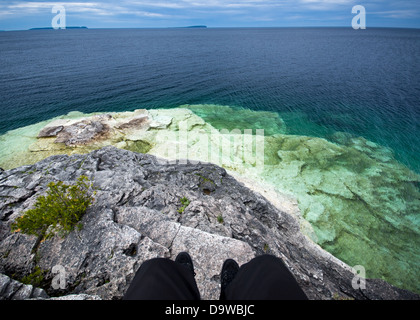 Prospettiva in prima persona di seduta su una rupe su Georgian Bay a Bruce Peninsula National Park in Ontario, Canada. Foto Stock