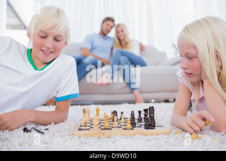 Bambini che giocano a scacchi nel soggiorno Foto Stock