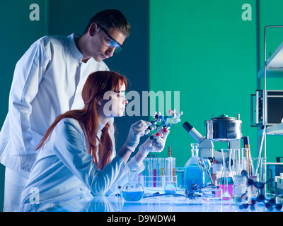 Vista laterale di due giovani scienziati caucasica studiando una struttura molecolare in un laboratorio Foto Stock