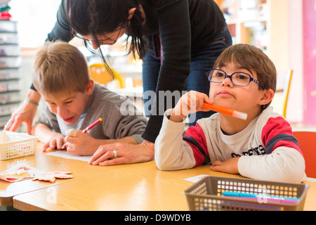 7 anni vecchio ragazzo della sindrome di Down e insegnante specialista di primo grado educati in un IME Istituto Medical-Educational Montmoreau Foto Stock