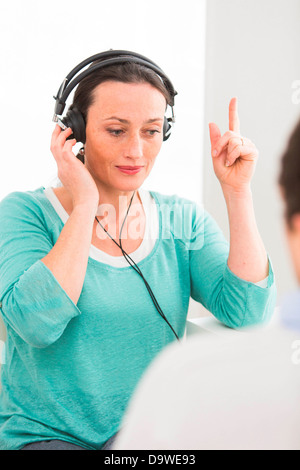 Donna subendo pure-tono di prova l'audiometria Foto Stock