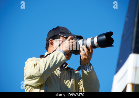 Turista giapponese con la fotocamera sulla sommità del monte Eden, Auckland, Nuova Zelanda. Foto Stock