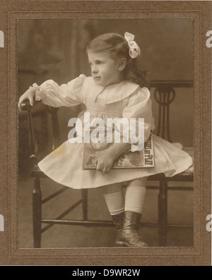 Originale primo 1900's Edwardian studio ritratto di giovane ragazza che tiene un libro, circa 1904. REGNO UNITO Foto Stock