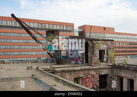 Il tetto dell'Alte Eisfabrik rovina industriale a Berlino, Germania, con il Verdi union building in background. Foto Stock