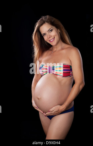 Allegra donna incinta indossando un bikini Foto Stock