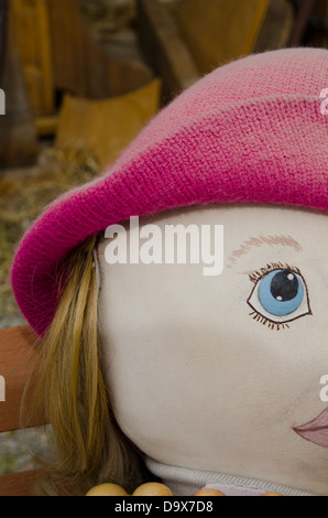 Parte di un espressivo doll face con disegnati a mano gli occhi e labbra, un cappello di maglia e capelli veri. Foto Stock