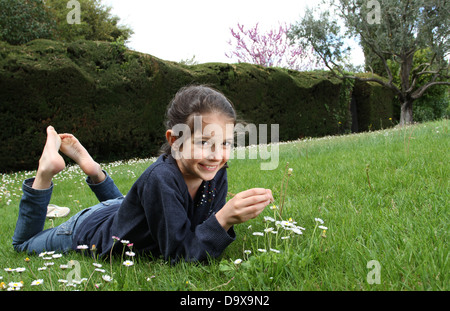 Giovane ragazza in posa di un giardino situata sul prato Foto Stock