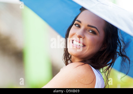 Felice giovane donna holding ombrello in caso di pioggia Foto Stock