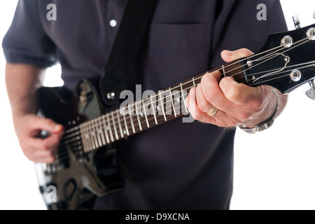 Vista ravvicinata della mano sinistra di un uomo diteggiatura una corda sulla tastiera di una chitarra elettrica. Foto Stock