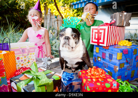 Due bambini e cane a outdoor festa di compleanno Foto Stock