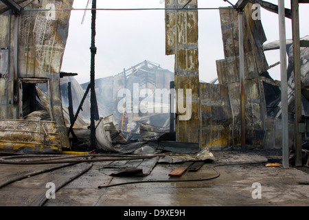 Un vigile del fuoco nel mezzo di un edificio è crollato da un incendio Foto Stock