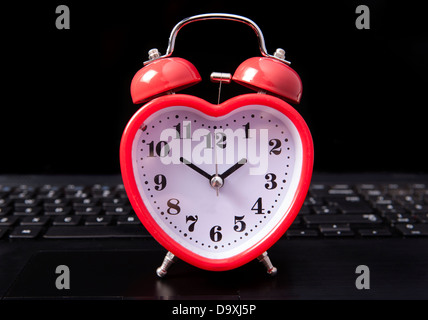 Cuore orologio su un computer portatile Foto Stock