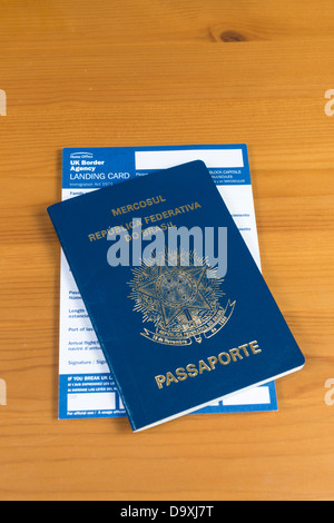 Passaporto brasiliano con UK carta di sbarco all'interno. Isolato sul modello in legno. Foto Stock