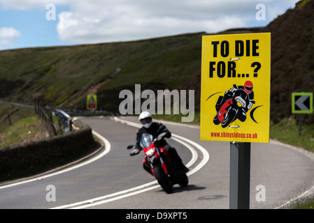 Segnale di avvertimento per i motociclisti sullo Snake Pass A57 Road Derbyshire con persona in sella a una moto in background Foto Stock