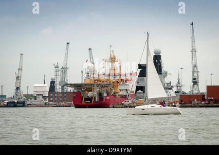 HMS protettore e HMS Diamond ormeggiata nel porto di Portsmouth Regno Unito con una barca vela passato Foto Stock