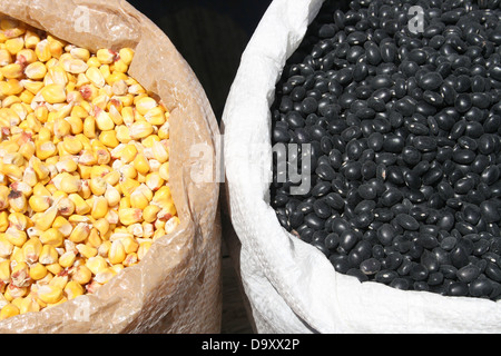 Fagioli neri e chicchi di mais giallo per la vendita presso il cibo all'aperto Mercato di Otavalo, Ecuador Foto Stock