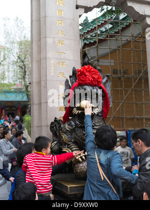 Dh Wong Tai Sin Temple WONG TAI SIN HONG KONG toccando cinese Foo cane Statua di Lion per buona fortuna persone cina Foto Stock