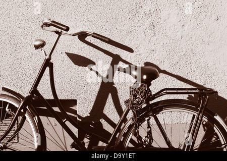 Bicicletta vintage parcheggiato contro una parete. Foto Stock