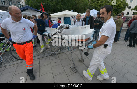 I paramedici tendono a partecipanti di uno sciopero della fame in una tenda provvisoria nel centro di Monaco di Baviera, Germania, il 28 giugno 2013. Il gruppo di richiedenti asilo ha iniziato la 'asciutto' sciopero della fame il martedì per il riconoscimento categorico delle loro domande di asilo. Foto: PETER KNEFFEL Foto Stock