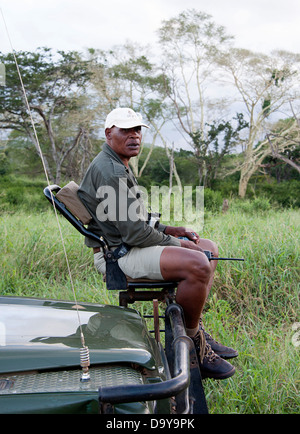 Co-driver si siede sul veicolo sede vista attaccata alla parte anteriore del land rover in Game Reserve, Sud Africa. Foto Stock