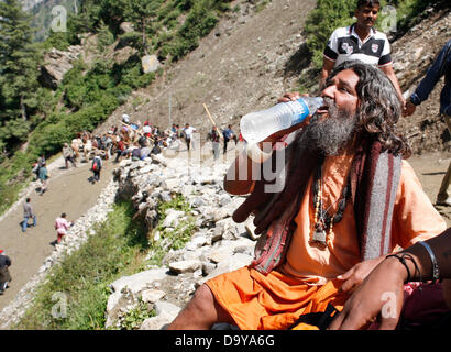 Baltal, Indiano Kashmir amministrato del 28 giugno 2013.Un indù uomo santo o (Sadhu) disseta come fa il suo pellegrinaggio da Baltal Campo Base al santo Amarnath grotta santuario, in Baltal . Ogni anno centinaia di migliaia di pellegrini in viaggio attraverso le montagne insidiose in rivolta-strappato il Kashmir, lungo ruscelli ghiacciati, alimentati da ghiacciai e laghi congelati passa, per raggiungere la grotta di Amarnath, situato ad un altitudine di 3857 metri (12,729 piedi), dove un Shiva lingam, una stalagmite di ghiaccio conformato come un fallo e simboleggia il dio indù Shiva, si distingue per il culto. (Sofi Suhail/ Alamy Live News) Foto Stock