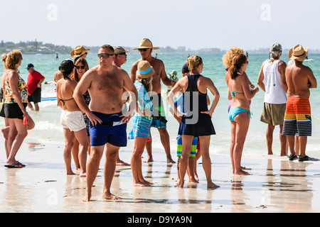 Spettatori guarda lo Stand Up Paddlerboard concorrenti sulla Siesta Key Beach FL Foto Stock