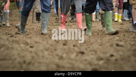 Glastonbury, Regno Unito. Il 28 giugno 2013. GLASTONBURY FESTIVAL DI MUSICA i frequentatori del festival indossando wellingtons a causa del fango appiccicoso che copre il terreno dopo un paio di ore di pioggia di ieri. Glastonbury Festival avrà luogo presso l'azienda agricola degna, Pilton Somerset. Giugno 28. 2013. GLASTONBURY FESTIVAL DI MUSICA PILTON, Somerset, Inghilterra, UK Credit: Alistair Heap Alamy/Live News Foto Stock