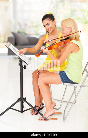 Sorridente maestro di musica di note di puntamento per violino studente Foto Stock