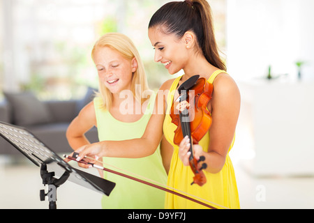 Piuttosto maestro di musica di note di puntamento al suo studente Foto Stock