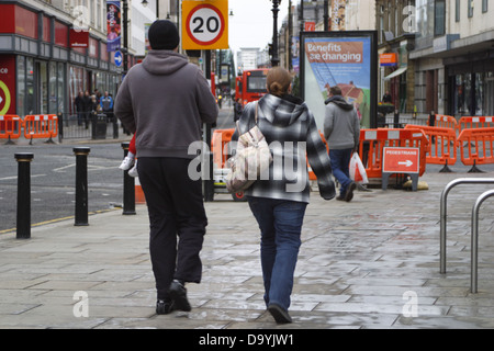 I pedoni a camminare in Sunderland city centre, un uomo e una donna sono visibili in primo piano centro, gli acquirenti sono visibili nella parte posteriore. Foto Stock