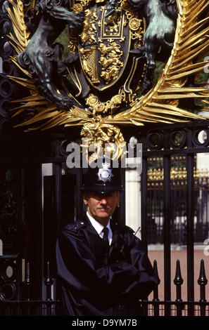 Un poliziotto britannico indossa custode tipico casco o casco centurion al cancello di Buckingham Palace Londra REGNO UNITO Inghilterra Foto Stock