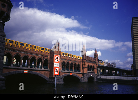 Un treno U-Bahn attraversa il ponte Oberbaum a due piani sul fiume Sprea a Berlino in Germania Foto Stock