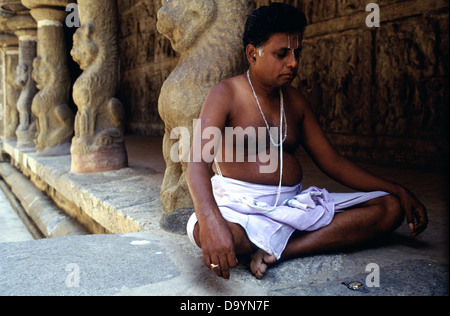 L'uomo locale seduto in posizione di loto meditando in Thiru Parameswara Vinnagaram o Vaikunta Perumal Tempio indù dedicato a Vishnu che si ritiene sia stato costruito dal re Pallava Narasimhavarman II (720-96 CE), Con i contributi successivi dei re medievali Cholas e Vijayanagar nello stile di architettura Dravidiana a Kanchipuram o Kanchi nello stato del Tamil Nadu Sud India Foto Stock