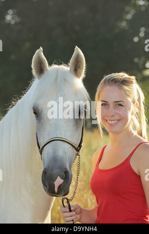 Ragazza e un colorato palomino Paso Fino a cavallo al mattino Foto Stock