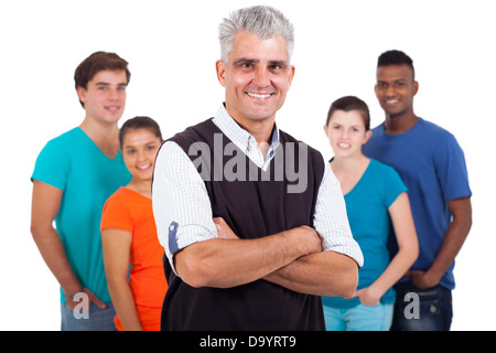 Felice di mezza età insegnante con le braccia incrociate di fronte agli studenti della scuola secondaria superiore isolata su sfondo bianco Foto Stock