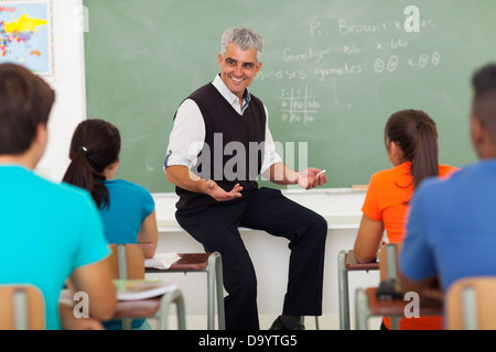 Amichevole maschio insegnante spiegando la lezione agli studenti in aula Foto Stock