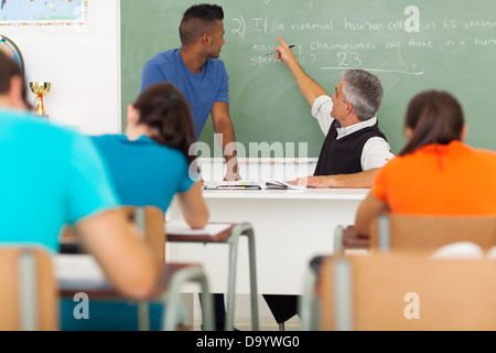 Senior high school biology maestro che insegna agli studenti in aula Foto Stock