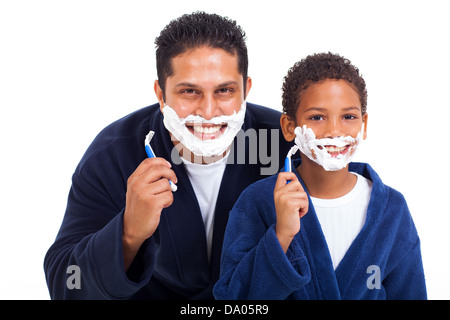 Giocoso little indian boy rasatura con padre isolato su bianco Foto Stock