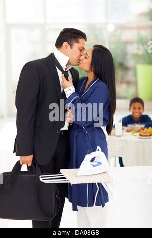 Amorevole marito baciare moglie prima di andare al lavoro Foto Stock