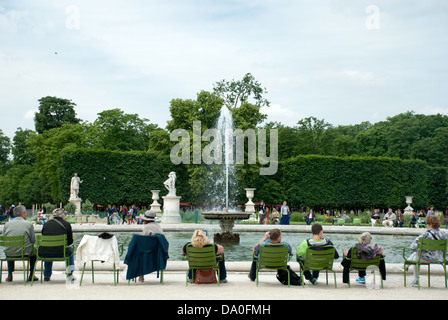 Persone in rilassanti sedie accanto a una fontana nel Jardin des Tuileries Parigi. Foto Stock