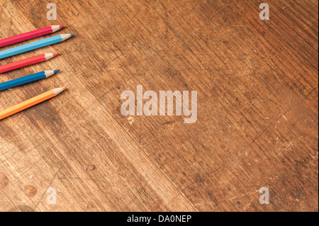 Graffiato e indossato il legname table top con matite colorate sul lato Foto Stock