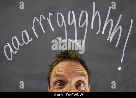 Testa di uomo di fronte a una lavagna con il messaggio, aaarrrggghhh Foto Stock