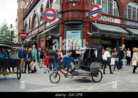 Urban Rickshaw o Pedicab con autista o ciclista al di fuori di Covent Garden Stazione della metropolitana Central London, England, Regno Unito Foto Stock