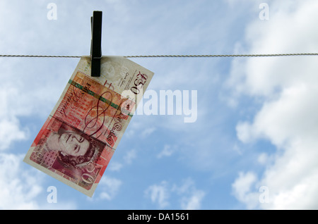 Cinquanta Pound Notes appeso su una linea di lavaggio Foto Stock